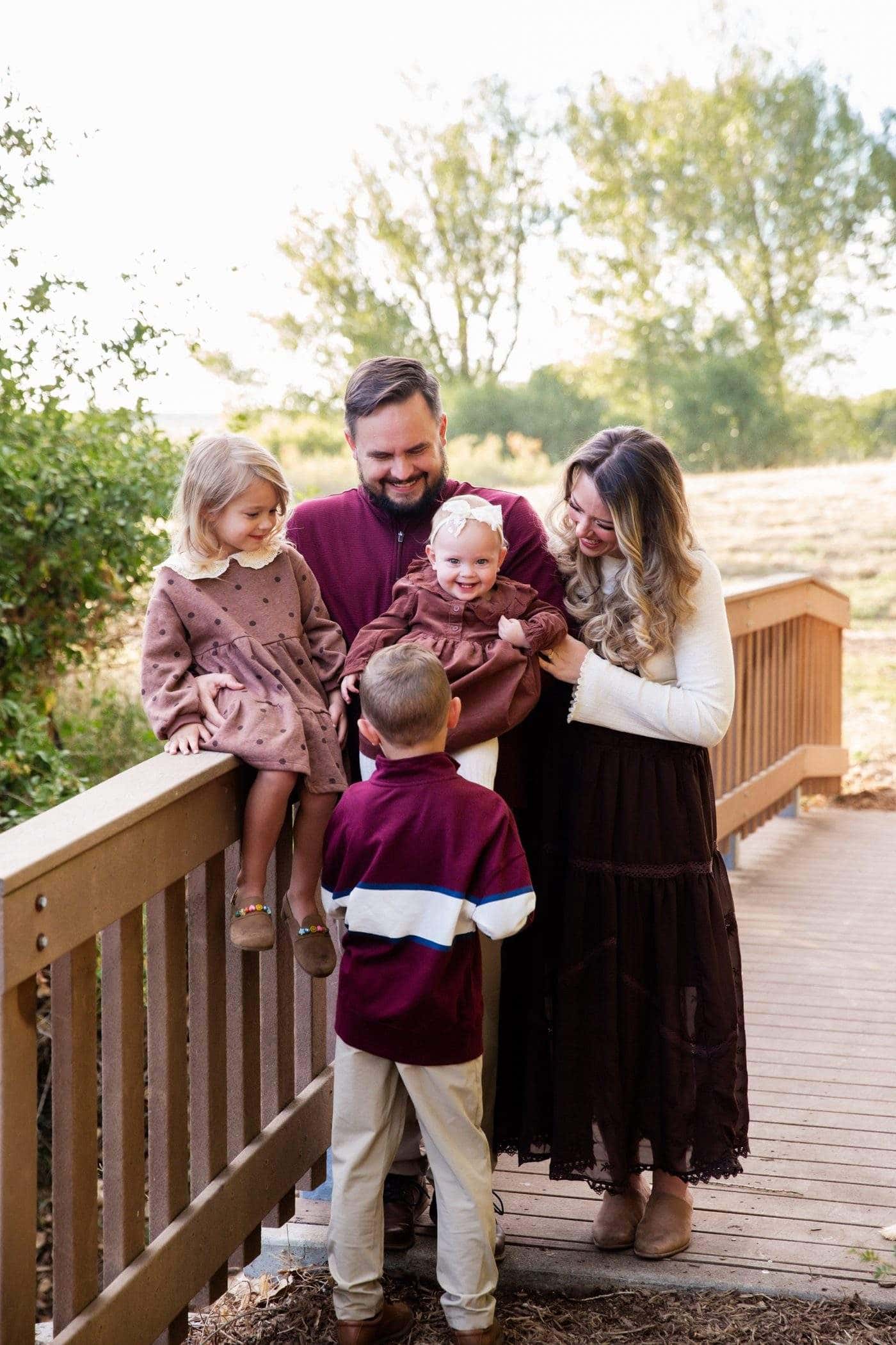 Isaac Hoffman with his wife and three children on a wooden bridge